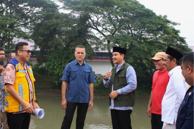 Wali Kota Tebingtinggi, H. Iman Irdian Saragih, mendampingi Anggota Komisi V DPR RI, Musa Rajekshah, serta Kepala Balai Besar Wilayah Sungai (BBWS) Sumatera II Medan, Feriyanto Pawenrusi, meninjau tanggul penahan banjir di sepanjang bantaran Sungai Padang, Jalan Anturmangan, Jumat (2/10/2026).